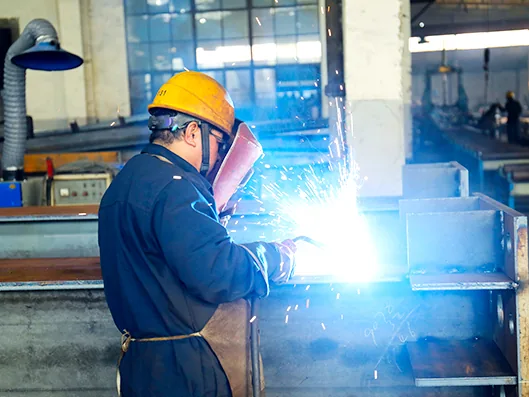 Welder fabricating steel structure components in the Trighero workshop